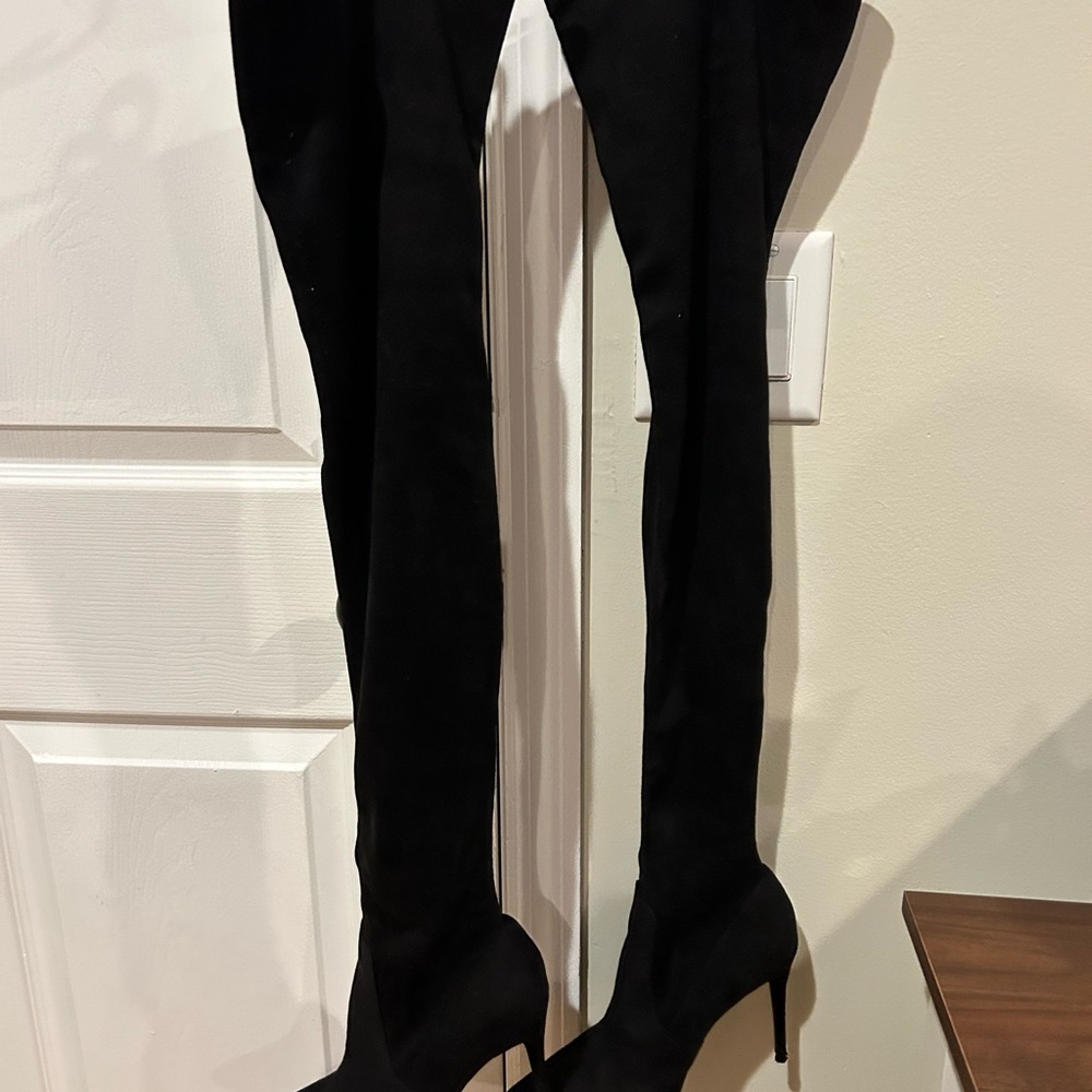 Women’s black thigh high stiletto boots.
